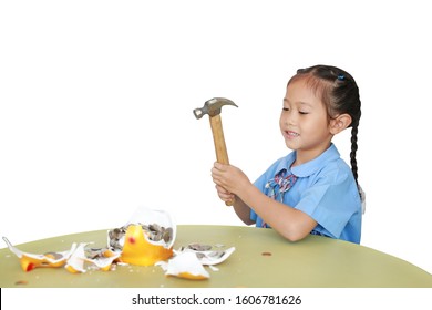 Asian Little Child Girl In School Uniform Breaking Piggy Bank Isolated On White Background At Table. Schoolgirl With Money Saving Concept.