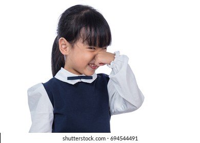 Asian Little Chinese Girl holding her nose because of a bad smell in isolated White Background