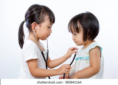 Asian Little Chinese Girls Playing as Doctor and Patient with Stethoscope isolated on white background
