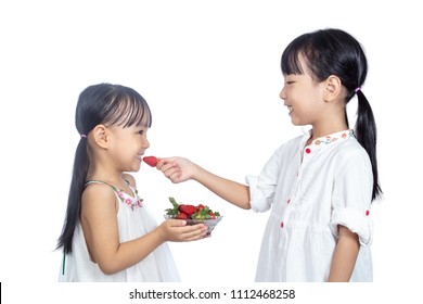 Asian Little Chinese sisters Eating Strawberry in isolated white background