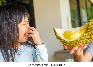 Asian Little Cute Girl Dislikes Eating Durian. Durian Fruit Is So Smelly And Pungent, Good Taste But Bad Smell.