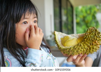 Asian Little Cute Girl Dislikes Eating Durian. Durian Fruit Is So Smelly And Pungent, Good Taste But Bad Smell.