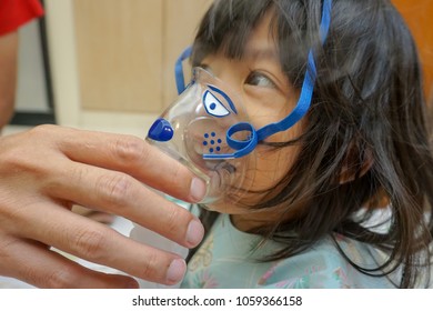 Asian Little Cute Girl With Influenza Hospital Admission. 
Father Holding  The Mask Of Inhaler For His Kid, Getting Bronchodilator.
