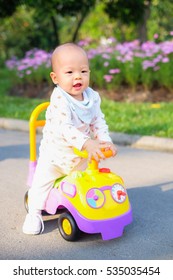 Asian Little Cute Toddler Baby Boy Learning To Ride His First Running Colorful Bike In Public Park, Bangkok Thailand