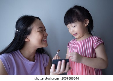 Asian Little Daughter Doing Make Up Her Mom. Concept Of Love And Connection Of Mother And Kid.