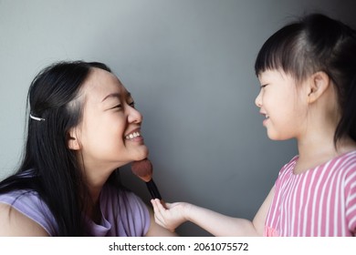 Asian Little Daughter Doing Make Up Her Mom. Concept Of Love And Connection Of Mother And Kid.