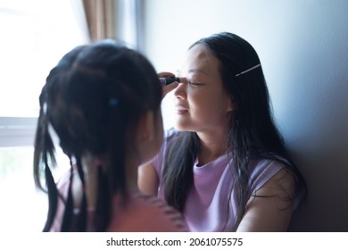 Asian Little Daughter Doing Make Up Her Mom. Concept Of Love And Connection Of Mother And Kid.