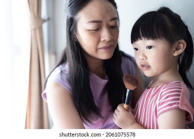 Asian Little Daughter Doing Make Up Her Mom. Concept Of Love And Connection Of Mother And Kid.