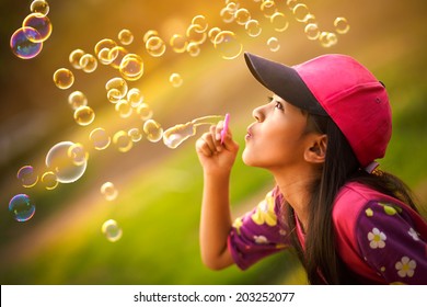 Asian little girl is blowing a soap bubbles