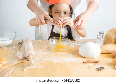 Asian Little Girl Breaking Shell Of Egg For Making Bakery