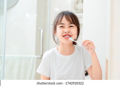 Asian Little Girl Brushing Her Teeth