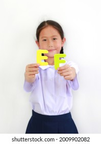 Asian Little Girl Child In School Uniform Holding Alphabet EF (Executive Functions) On White Background. Education Concept. Focus At Text In Hands