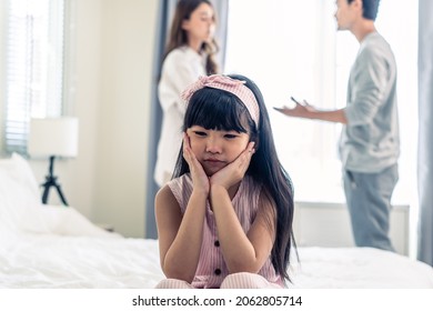 Asian Little Girl Crying While Parents Fighting Or Quarrel Conflict. Young Kid Daughter Sit On Bed Feel Heart Broken With Tears And Dont Want To See Violence At Home. Family Problem-separation Concept