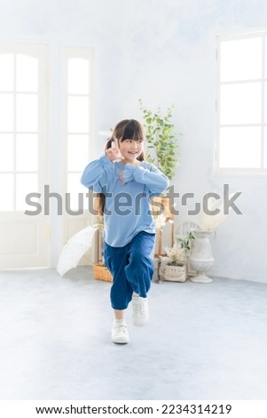 Asian little girl dancing in the room.