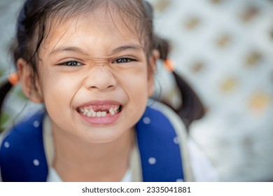 Asian little girl displays a missing tooth. - Powered by Shutterstock