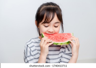 Asian Little Girl Eating Watermelon At Home