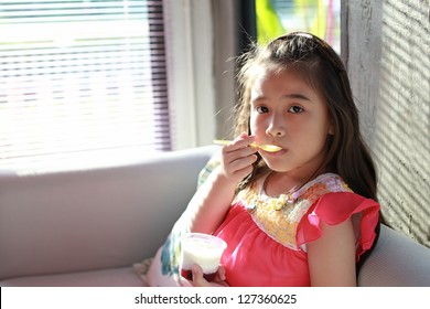 asian little girl eatting yogurt