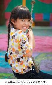 Asian Little Girl Enjoys Playing In A Children Playground