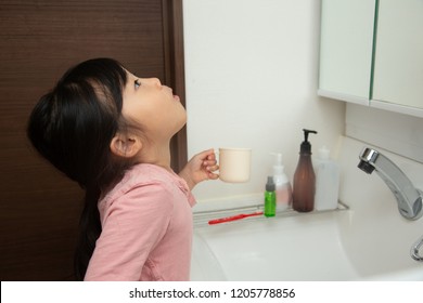 Asian Little Girl Gargling At Home