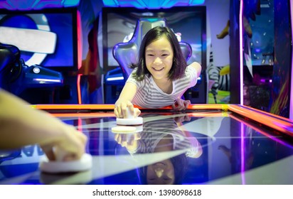 Asian Little Girl Playing Arcade Game On The Computer Machines At The Shopping Mall Outlets,holiday Activities Of Cute Child Play Games,slot Machines In The Mall Center,vacation Concept
