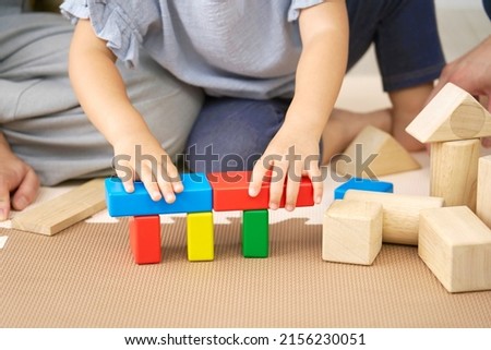 Asian little girl playing with the building blocks at home, no face