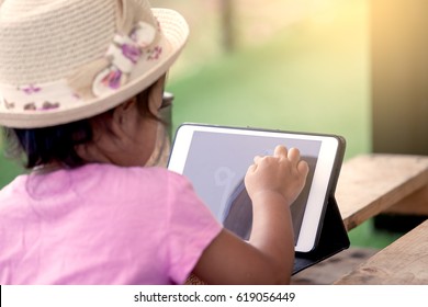 Asian Little Girl Is Playing Ipad Tablet In Vintage Color Tone