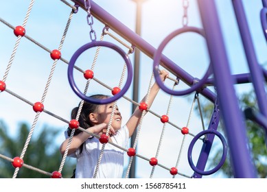Asian little Girl Playing at Playground outdoors. Kid climbing on rope. - Powered by Shutterstock