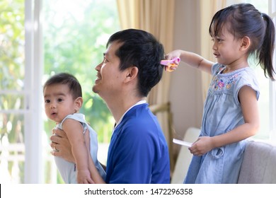 Asian Little Girl Is Playing As She Is Hairdresser In The Morning Time, Concept Of Role Of Parent To Care Their Child And Child Development Through Role Play, Happy Time In Family Lifestyle.