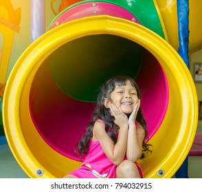 Asian little girl playing slider indoor playground on holiday - Powered by Shutterstock