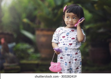 Asian Little Girl Playing Toy Phone 