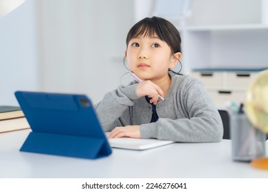 Asian little girl studying with a tablet PC. - Powered by Shutterstock