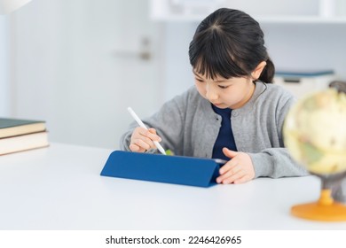 Asian little girl studying with a tablet PC. - Powered by Shutterstock