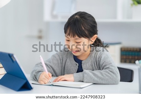 Asian little girl studying with a tablet PC.