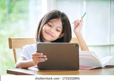 Asian little girl taking class on line and happy for Homeschool Quarantine coranavirus pandemic concept