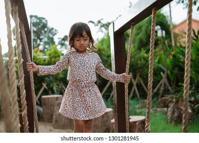 Asian Little Girl Very Carefully Hold A Rope When Standing On A Balance Beam Alone