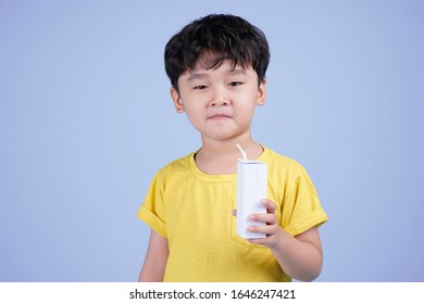 Asian little handsome child drinking milk from a box on color background isolated - Shutterstock ID 1646247421