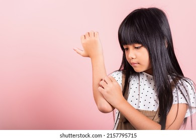 Asian Little Kid 10 Years Old Scratching Itch Arm From A Mosquito Bite At Studio Shot Isolated On Pink Background, Portrait Of Happy Child Girl Dermatitis And Scabies, Allergy Symptoms, Malaria Day
