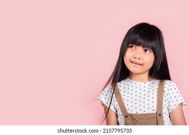 Asian Little Kid 10 Years Old Looking Away To Side Natural Expression At Studio Shot Isolated On Pink Background, Portrait Of Happy Child Girl Smiling Staring Away Thinking