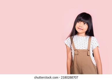 Asian Little Kid 10 Years Old Looking Away To Side Natural Expression At Studio Shot Isolated On Pink Background, Portrait Of Happy Child Girl Smiling Staring Away Thinking