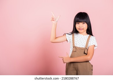 Asian Little Kid 10 Years Old Point With Index Finger Up At Studio Shot Isolated On Pink Background, Happy Child Girl Lifestyle Pointing To Empty Place