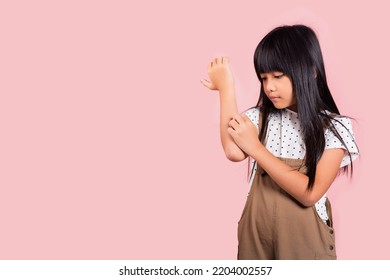 Asian Little Kid 10 Years Old Scratching Itch Arm From A Mosquito Bite At Studio Shot Isolated On Pink Background, Portrait Of Happy Child Girl Dermatitis And Scabies, Allergy Symptoms, Malaria Day