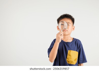 Asian little kid boy funny looking through magnifying glass at studio shot isolated on white background, Happy primary child lifestyle smiling exploring holding magnifier searching, Education - Powered by Shutterstock