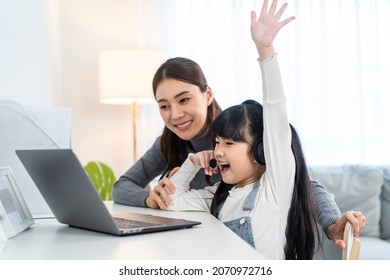 Asian Little Young Girl Kid Learning Online Class At Home With Mother. Preschool Child Use Laptop Computer Do Homework, Homeschool From School Teacher By Digital Remote Internet With Support From Mom.