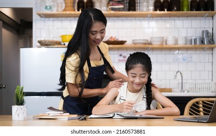 Asian Little Young Girl Kid Learning Online Class At Home With Mother. Preschool Child Use Laptop Computer Do Homework, Homeschool From School Teacher By Digital Remote Internet With Support From Mom
