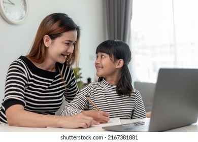 Asian Little Young Girl Kid Learning Online Class At Home With Mother. Preschool Child Use Laptop Computer Do Homework, Homeschool From School Teacher By Digital Remote Internet With Support From Mom.