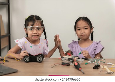 Asian littlle girl constructing and coding robot at STEM class,Fixing and repair mechanic toy car