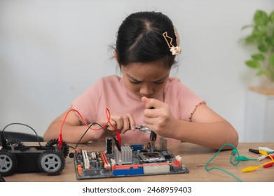 Asian littlle girl constructing and coding robot at STEM class,Fixing and repair mechanic toy car - Powered by Shutterstock