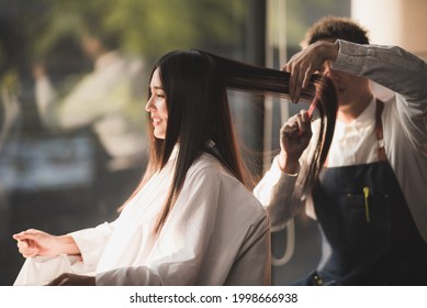 Asian Long Black Straight  Hair Female Cutting Her Hair At Luxery Salon With Professional  Dresser With Scissor Tool.