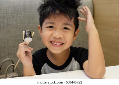 Asian Lovely Boy Is Eating Sushi