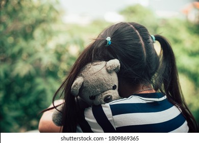 Asian lovely child girl hug teddy bear with love
